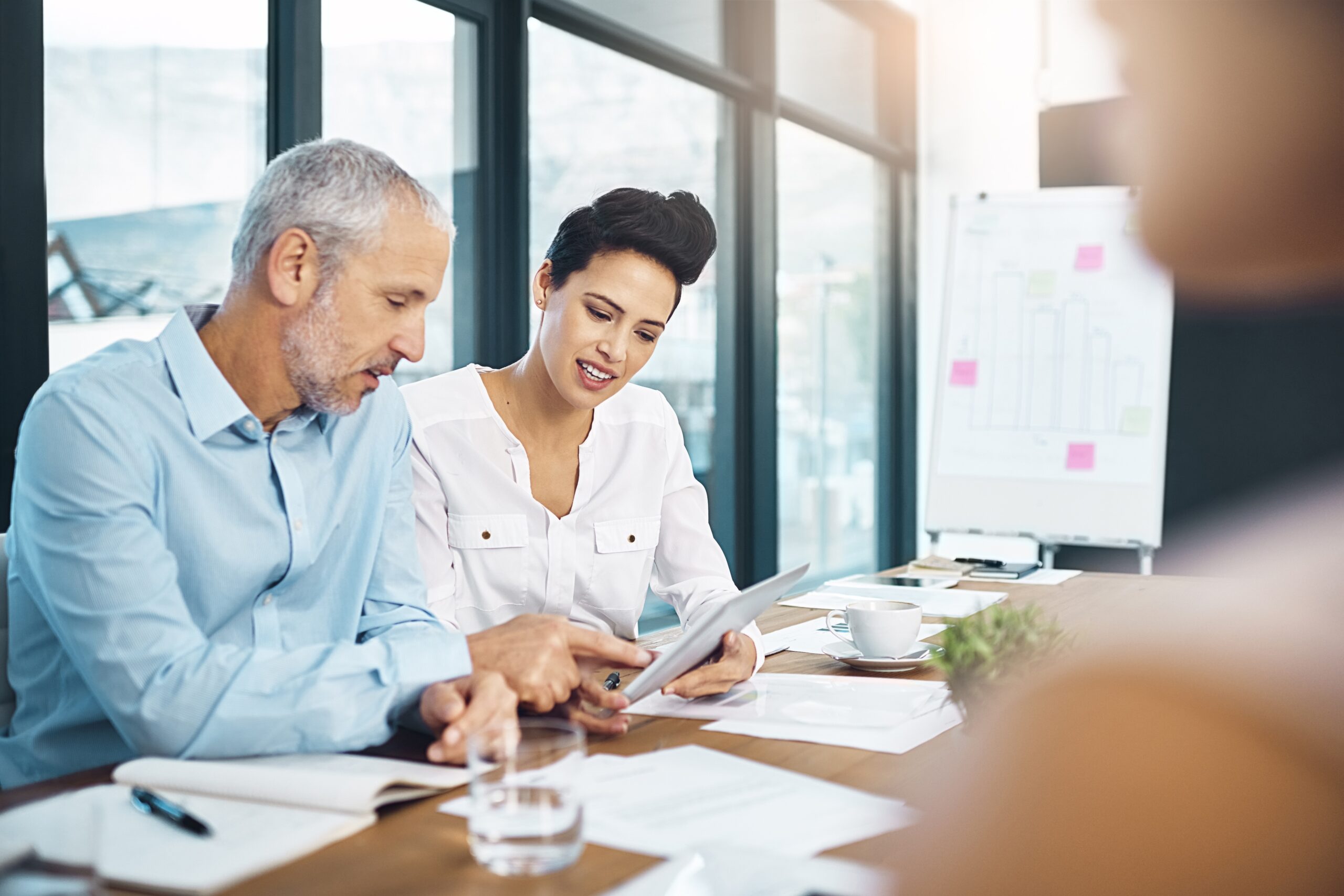A leader sitting with one team member reviewing work