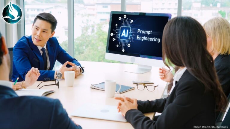 Leaders around a work conference table talking with a computer screen that says AI Prompt Engineering